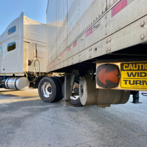 sign read” Caution ,Wide turns”with orange led arrow underneath the truck