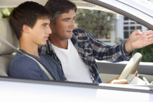 Father teaching teenager how to drive