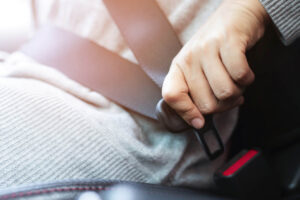 Car passenger adjusting their seat belt