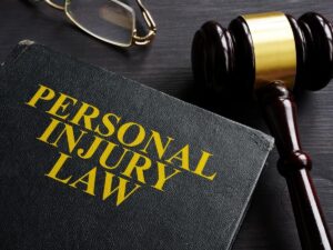 Book with personal injury law written on the cover, and wooden gavel