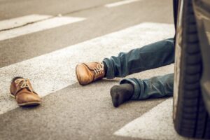 Man in front of a car on the road after a pedestrian accident