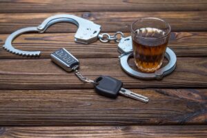 Alcohol, car keys, and handcuffs on top of a table